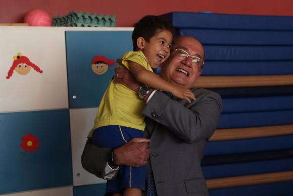 O presidente do TSE, Gilmar Mendes, carrega uma das crianças da Casa da Mãe PretaJosé Cruz/Agência Brasil