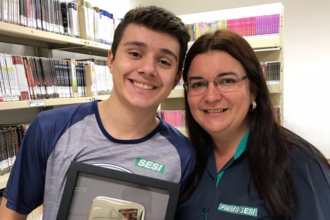 O estudante João Vitor, de 17 anos, aluno da 3ª série do Ensino Médio da Escola do Sesi de Dourados, recebeu placa de 100 mil inscritos concedida pelo YouTube aos criadores de conteúdos no canal que atingem essa meta.