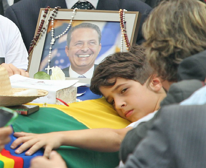 Filho de Campo abraça o caixão com os vestígios do corpo do pai (Foto: Divulgação)
