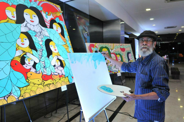 Artista plástico Ilton Silva pinta tela ao vivo durante abertura de sua exposição no hall do Edifício Casa da Indústria em Campo Grande. (Foto: Divulgação)