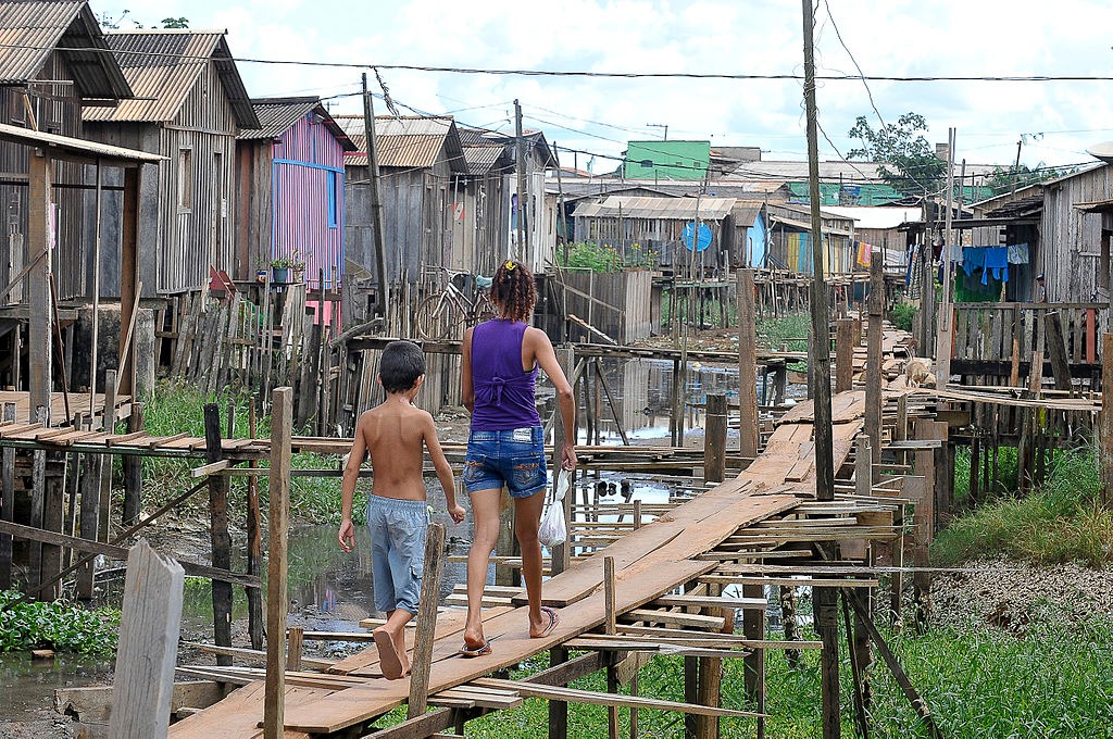 Em meio à falta de saneamento, moradores equilibram-se em ‘ruas’ de madeira para chegar a suas casas em Altamira, no Pará. Foto: Valter Campanato/ABr